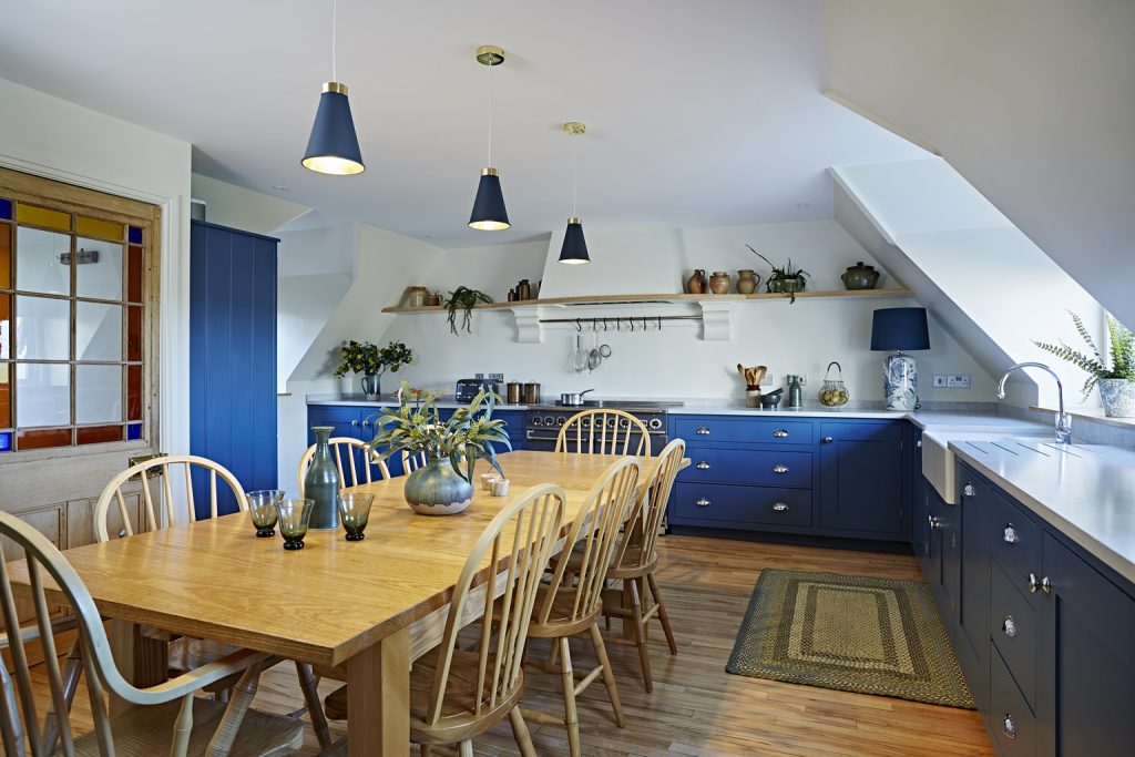A large bright family kitchen with long oak table in the centre